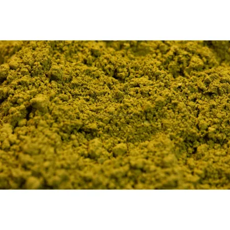 Intensywnie zielona chińska herbata Matcha w formie drobnego proszku w ceramicznej miseczce.